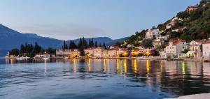 a town on the shore of a body of water at Rose - Apartmani Janovic in Lustica