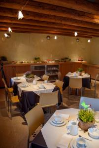 a restaurant with tables and chairs and a kitchen at Agriturismo Antico Splendore in Pullir