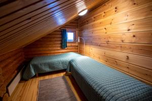 Habitación con 2 camas en una cabaña de madera en Villa Tuulahdus, Sorjosen lomamökit en Savonlinna