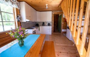 una cocina con una mesa con un jarrón de flores. en Villa Tuulahdus, Sorjosen lomamökit en Savonlinna