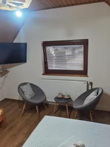 2 Stühle und ein Tisch in einem Zimmer mit einem TV in der Unterkunft House Nada in Rastovača