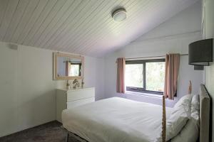Barmouth Bay Holiday Park في بارموث: غرفة نوم بسرير ابيض ونافذة