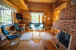 sala de estar con sofá, sillas y chimenea en Villa Tuulahdus, Sorjosen lomamökit en Savonlinna