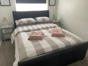 a bedroom with a bed with two pink bags on it at Self-contained, Framlingham Snug, Private Parking, no cooking facilities in Framlingham