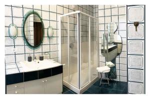 uma casa de banho com um chuveiro, um lavatório e um espelho. em Elegant Apartment San Babila ,5 minutes from Duomo em Milão