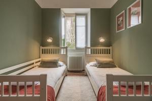 two beds in a room with green walls at Pescallo Mandarin by Wonderful Italy in Bellagio
