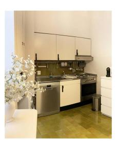 uma cozinha com um lavatório e um fogão em Elegant Apartment San Babila ,5 minutes from Duomo em Milão