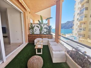 a balcony with a couch and a view of the ocean at Kayla - AzulenaCalpe in Calpe