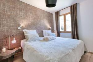 a bedroom with a large bed and a brick wall at La Collection - Le Village in Saint-Gervais-les-Bains