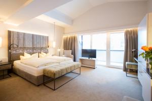a bedroom with a large bed and a television at Hotel Rita in Längenfeld +50 photos