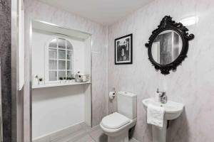 ein Badezimmer mit einem WC, einem Waschbecken und einem Spiegel in der Unterkunft VIP city centre apartment with secure free parking in Liverpool