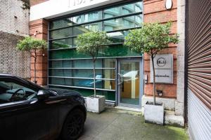 ein schwarzes Auto, das vor einem Gebäude parkt in der Unterkunft VIP city centre apartment with secure free parking in Liverpool