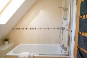 a bathroom with a bath tub in a attic at The Pilot House - Cowes in Cowes +21 photos