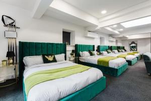 Zimmer mit 3 Betten und grünen Kopfteilen in der Unterkunft VIP city centre apartment with secure free parking in Liverpool
