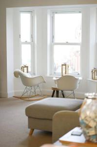 a living room with two chairs and a couch and two windows at The Pilot House - Cowes in Cowes