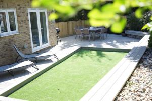 a patio with a table and chairs and grass at The Pilot House - Cowes in Cowes