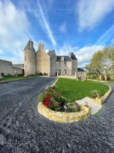 a large castle with a road in front of it at Château de Bernesq in Bernesq