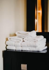 a stack of white towels sitting on top of a counter at Obrava Guesthouse Kotroni Trikalon in Kotrónion