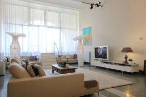 uma sala de estar com um sofá e uma televisão em Giudecca Luxury Gallery em Veneza