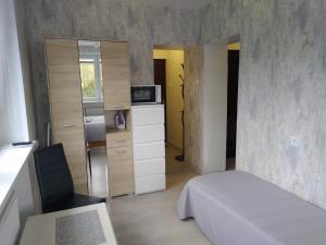 a small bedroom with a bed and a microwave at Poilsis Palangoje pas Daivą in Palanga