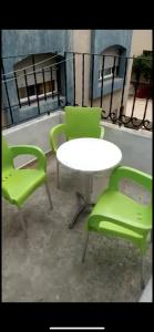 2 chaises vertes, une table, une table et des chaises dans l'établissement مهدية تجزئة العامرية, à Kenitra