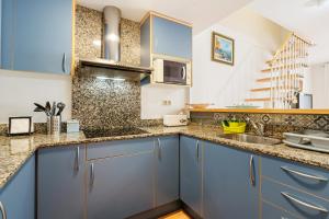 een keuken met blauwe kasten en een wastafel bij Apartamento Welcs EMP 060 con Terraza y Piscina in Empuriabrava