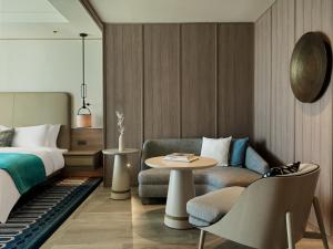a bedroom with a bed and a table and a chair at City of Dreams Mediterranean - Integrated Resort, Casino & Entertainment in Limassol
