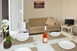 オートラントにあるMARIMAR - Apartments OTRANTOのリビングルーム(ソファ、ワイングラス付きのテーブル付)