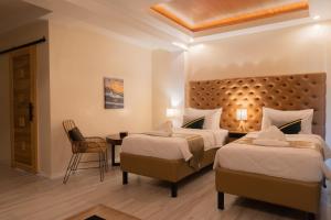 um quarto de hotel com duas camas e uma mesa em The Mayana Resort em Dauis