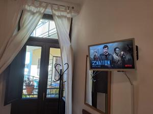 ein Flachbildfernseher an einer Wand neben einem Fenster in der Unterkunft La Terrazzina, silenzioso, zona Piazza Gran Madre in Turin