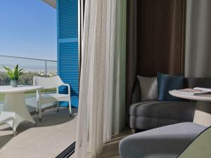 a room with a balcony with a table and chairs at City of Dreams Mediterranean - Integrated Resort, Casino & Entertainment in Limassol