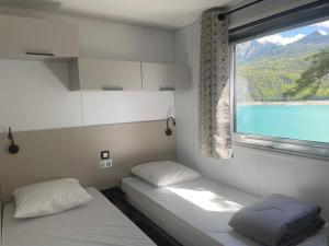 2 Betten in einem Zimmer mit Fenster in der Unterkunft Sunêlia Camping la Presqu'île in Prunières