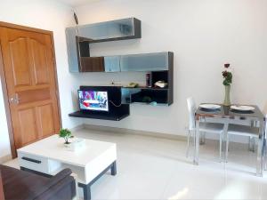 een woonkamer met een tv en een tafel en stoelen bij Cat Mama Penthouse Vtwin building A in Chiang Mai