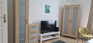 a living room with a tv on a white cabinet at GOLD 3 in Sopron