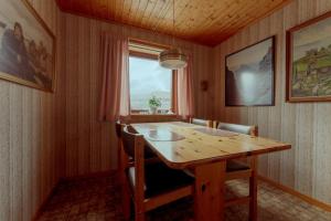 jadalnia z drewnianym stołem i oknem w obiekcie 3-Bedroom Home in Eiði 