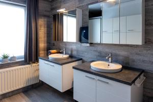 a bathroom with two sinks and a large mirror at Villa Op de Voort (XL, 12-22 personen) in Heusden - Zolder