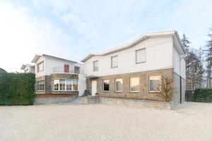 a large white house with a driveway at Villa Op de Voort (XL, 12-22 personen) in Heusden - Zolder