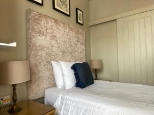 a bedroom with a bed with a blue pillow on it at Virginia Court Hotel in Cromer
