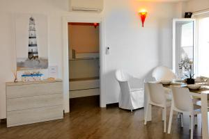 a dining room with a table and a lighthouse on the wall at MARIMAR - Apartments OTRANTO in Otranto