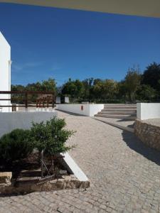 un patio con un árbol y un edificio en Monte Papa Figos, en Malhão