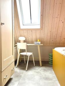 een stoel en een bureau in een kamer met een raam bij Herberg Swaen aan de Brink in Den Ham
