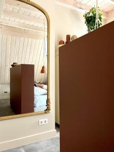 a mirror on a dresser in a room with a bed at Herberg Swaen aan de Brink in Den Ham