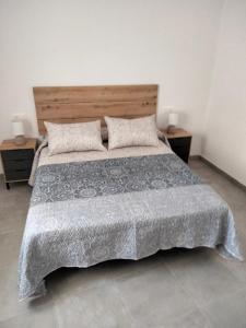 een slaapkamer met een groot bed en 2 nachtkastjes bij MARiPEP Playa Vinaròs in Vinarós