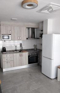 een keuken met witte apparatuur en een witte koelkast bij MARiPEP Playa Vinaròs in Vinarós