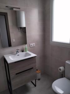 a bathroom with a sink and a mirror and a toilet at MARiPEP Playa Vinaròs in Vinaròs