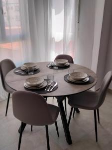 a wooden table with chairs and plates on it at MARiPEP Playa Vinaròs in Vinaròs