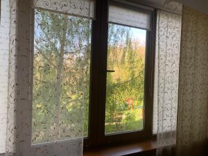 two windows with curtains and a view of a yard at Apartaments Teris in Zhytomyr