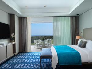 リマソールにあるCity of Dreams Mediterranean - Integrated Resort, Casino & Entertainmentのベッドと大きな窓が備わるホテルルームです。