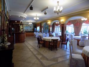 a dining room with white tables and chairs at Pensjonat Angela in Łeba