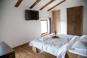 1 dormitorio con 1 cama y TV en la pared en Boutique Rooms & Winery Žorž en Vipava